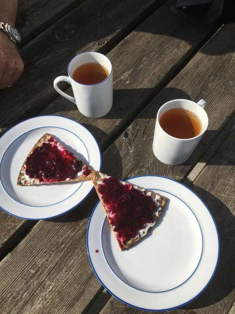 Zwei Teller mit Kuchen und zwei Becher Tee