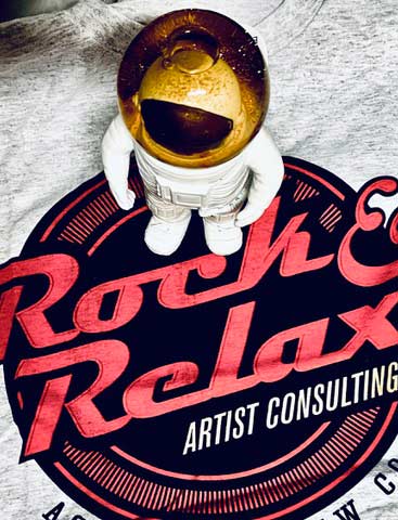 Astronautenfigur steht auf dem Rock & Relax-Logo 